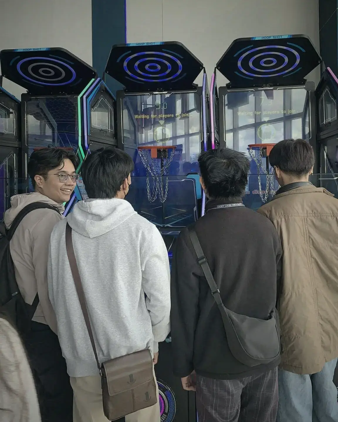 Interns watching an arcade hoop-shot machine after hours