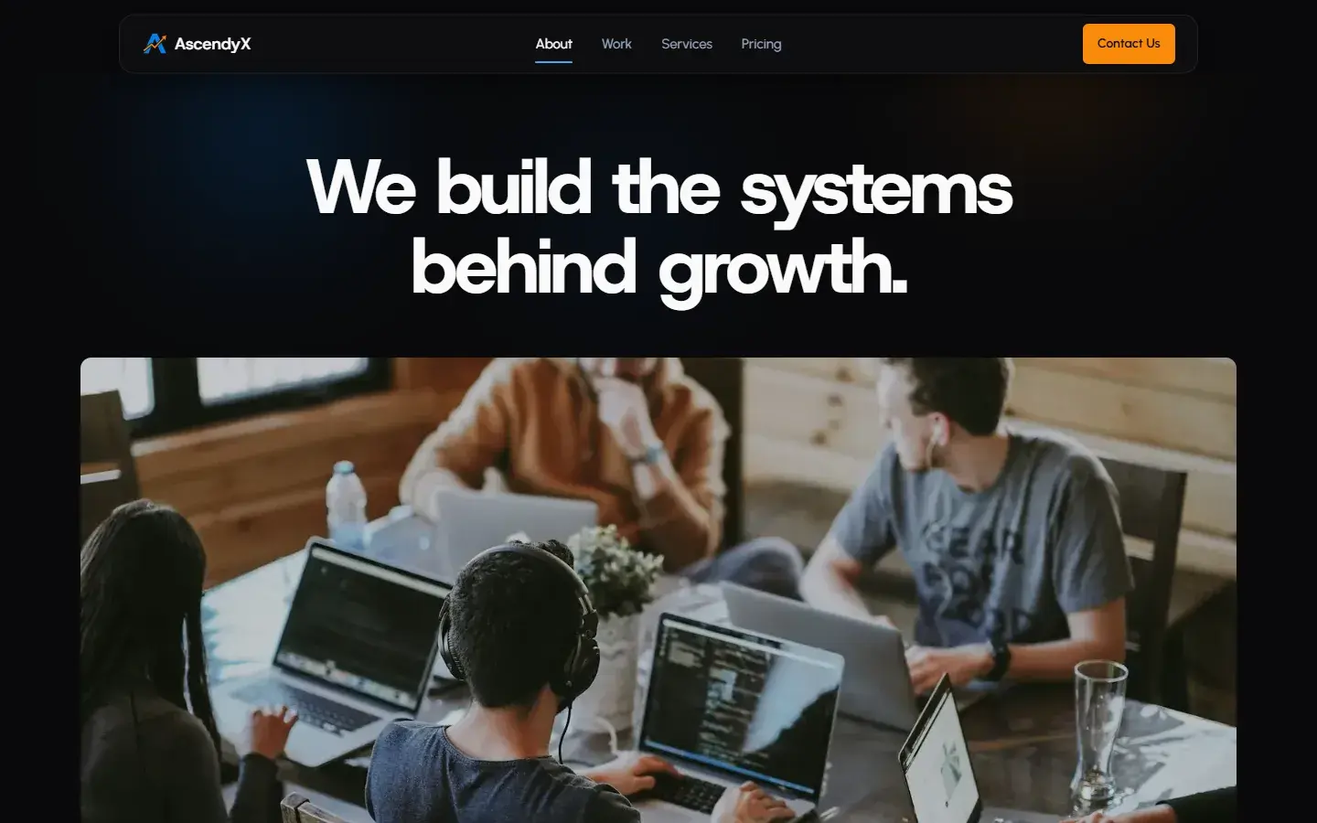Current about page: We build the systems behind growth, above a photo of a team at laptops